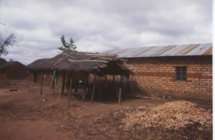 Die Werkstatt von Herrn Kihombo (der Unterstand mit dem Grasdach) und sein Wohnhaus.